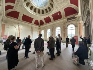 A tour group inside the main hall, looking up at the domed ceiling.